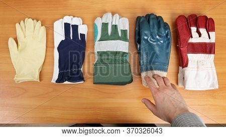 Gloves Are Laid Out On The Table And Have Different Degrees Of Protection. A Person Decides Which On