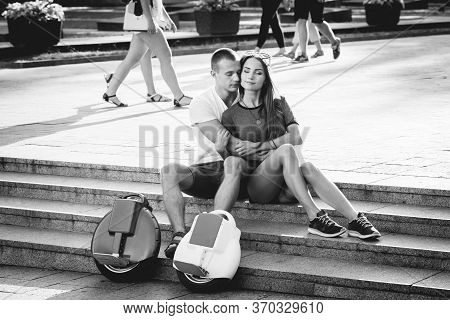 Young Couple Driving On Monowheel In The Park