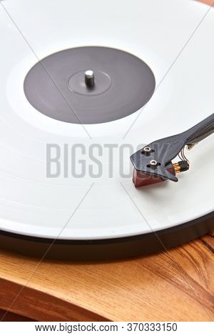 Old-fashioned vintage turnable record player with retro vinil disc on a wooden table, copy space. Popular disco trends 60s, 70s, 80s, 90s.