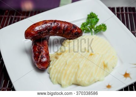 Potatoe With Sousages On The White Plate. Barbecue.