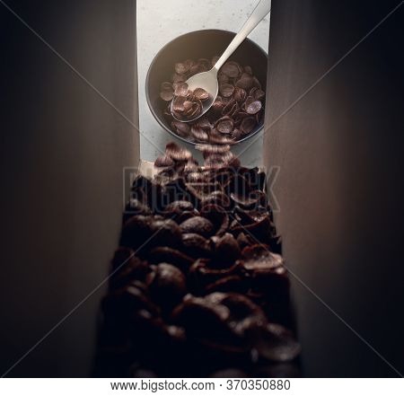 Cereal Chocolate Breakfast Out Of The Carton Into Bowl With Spoon.
