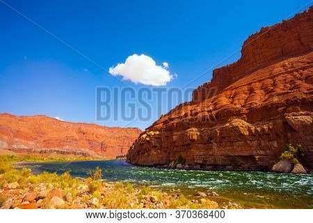  Lee's Ferry is a historic boat ferry across the Colorado River. USA. Stormy wide river with rapids and steep banks of red sandstone and cold water. The concept of active and photo tourism