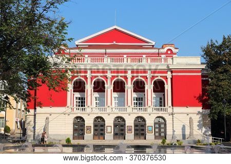 Rousse, Bulgaria - August 18, 2012: People Walk By Rousse State Opera In Ruse, Bulgaria. Ruse (also 