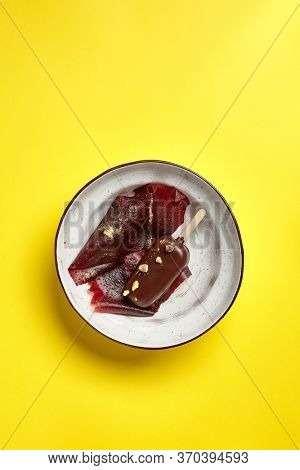 Chocolate mousse dessert top view. Luxury restaurant sweet course side view. Ice cream served with pastila in deep craft plate. Fancy confectionery dish with jellied fruit sweetmeat. Sweet food