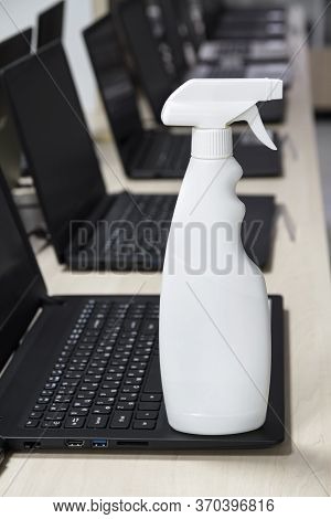 Disinfectant Bottle Against The Background Of The Interior Of A Computer Store. Protection From Bact