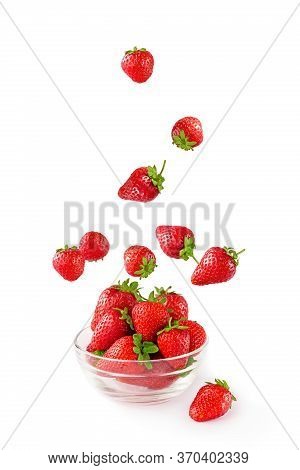 Flying Fresh Strowberries In Transparent Glass Bowl Isolated On White. Falling Berries On White Back