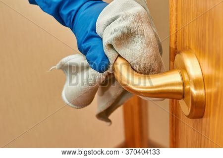 Woman Hand In Blue Protective Glove Using Disinfectant And Cleaning Cloth To Clean Doorknob From Vir