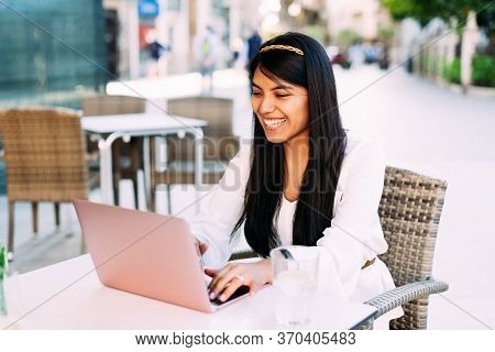 Latin Young Brunette Woman Sitting On Bar Terrace Working With Laptop. Lifestyle Concept