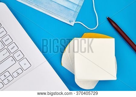 Concept Work From Home. Notebook, Protective Madical Face Masks, Pen, Stack Of White Note Papers On