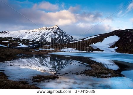 Icelandic Landscape With Frozen Lake And Stapafell Mountains Covered In Snow And Reflected On Water 