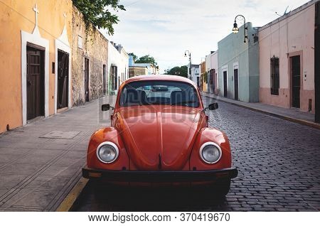 Merica, Yucatan, Mexico - 28 October 2018 - Front Of Red Oldtimer Volkswagen Beetle In The Colonial 