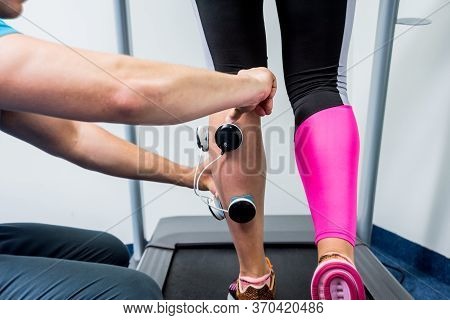 Physical Therapist Install Electrostimulator On The Muscles Of The Legs