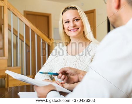 Happy Family Filling Questionnaire For Employee With Laptop Of The Bank At Table