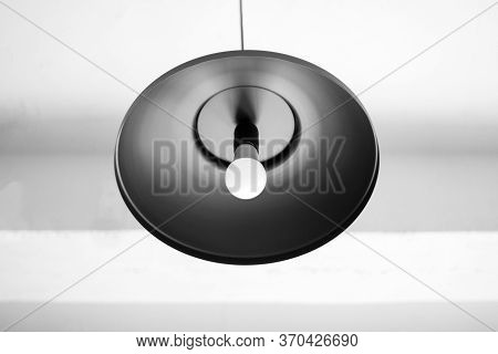 Сhandelier Black Hangs Down From A Ceiling. White Ceiling. The Bulb In A Chandelier Doesn't Burn.