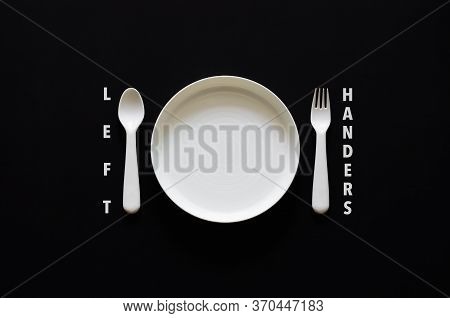 Spoon Put On Left Side Of The Dish On Black Background For International Left Handers Day Concept