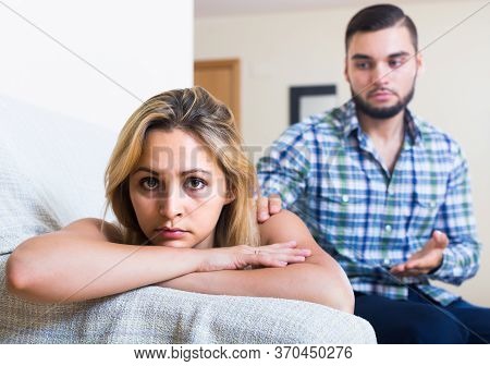 Sad European Adult Asking Offended Partner For Forgiveness At Home