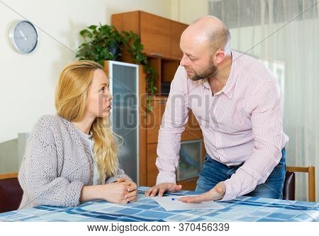 Serious Adult Family Erading Financial Documents At Home