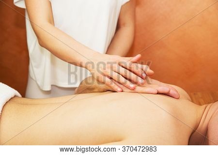 Man Procumbent With Hands Of Masseur With White Towels