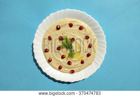 Famous Traditional Arabic, Eastern And Israel Cuisine - Tahini Dip With Pomegranate On Blue Backgrou