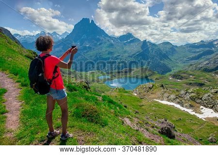 Hiking Woman Taking A Picture Of Pic Du Midi Ossau In The French Pyrenees Mountains
