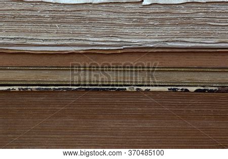 Close-up View Of Old Books Piled Up One On Top Of The Other