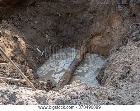 Damaged Rusty Water Pipeline Breaks In Deep Ditch Trench. City Infrastructure Repairing Working Proc