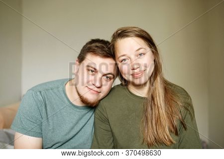 Close-up Portrait Of Tired Beautiful Married Couple In Casual Clothes Sitting At Home Together Durin