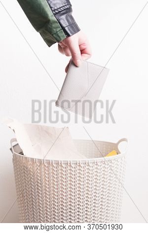 Female Hand Throws A Purse Into A Trash Can, A Woman In A Jacket And A Trash Can, White Background, 