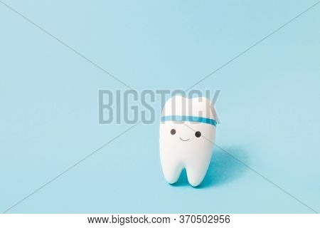 Happy Tooth On A Blue Background, Copy Space, Oral Care Concept, Toy Tooth Model, Pediatric Dentistr