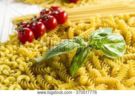   Curly Pasta And Basil Leaf On The Table