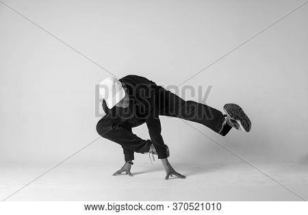 A Man Hip Hop Dancer Or Bboy Freezes In One Pose On A White Background. Bboy Doing Stylish Stunts.