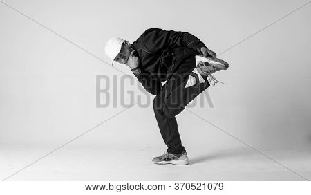 A Man Hip Hop Dancer Or Bboy Freezes In One Pose On A White Background. Bboy Doing Stylish Stunts.