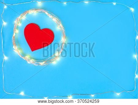 Decorations In The Shape Of Heart On A Blue Background With A Garland.