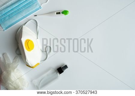 Medical Protective Mask, Respirator Ffp, Rubber Gloves, Thermometer And Antiseptic Lie On A Gray Bac