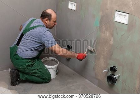 Bathroom Renovation. Construction Worker. Mineral Moisture Insulation. During Work.