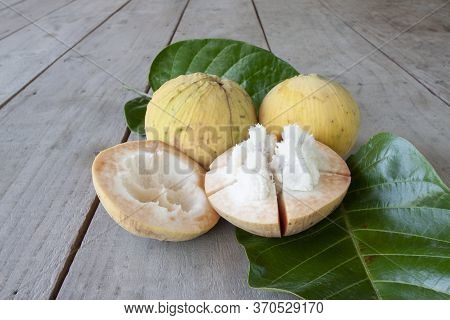 Half Cut Ripe Santol Or Sentul Fruit (sandoricum Koetjape) With Leaf On Wooden Table.