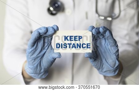 A Doctor Hold Card In His Hands With Text Keep Distanse, Protect From Coronavirus Or Covid-19 Epidem