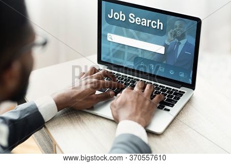 Employment Concept. Back View Over The Shoulder Of Black Man Using Laptop With Job Search Engine On 