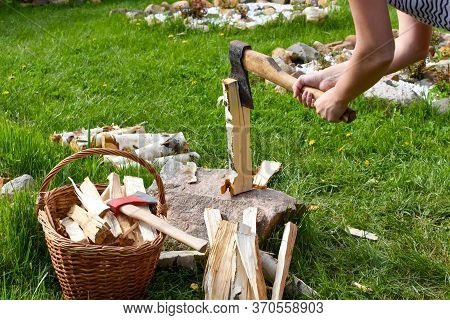 Woman Chopping A Log With An Ax In The Garden. Rural Life In The Summer. Chopping Firewood In The Fr