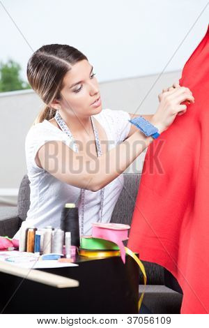 Femmina sarta vestiti su manichino sartoria di regolazione.
