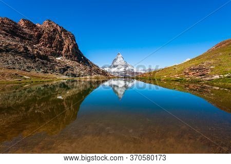 Riffelsee Lake And Matterhorn Mountain In The Alps, Located Between Switzerland And Italy
