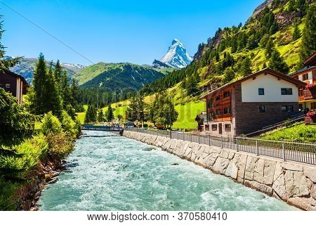 Traditional Local Houses Near The Matter Vispa River In The Centre Of Zermatt Town In The Valais Can