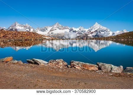 Riffelsee Lake And Matterhorn Mountain In The Alps, Located Between Switzerland And Italy