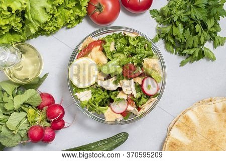 Mediterranean Pita Salad That Includes Lettuce, Tomatoes, Cucumbers, Radishes