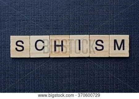 Text On Word Schism From Gray Wooden Letters On A Black Background