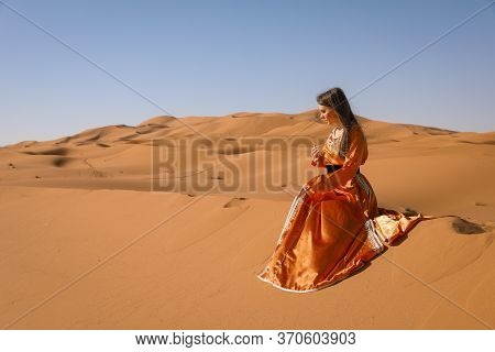 Beautiful Young Girl In Moroccan Dress In Sahara Desert.