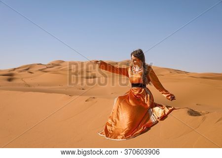 Beautiful Young Girl In Moroccan Dress In Sahara Desert.