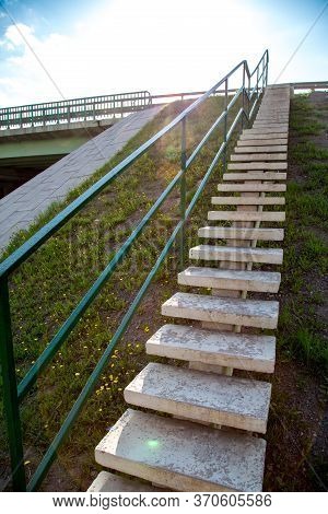 View Of A Concrete Staircase On The Slope Of A Road With Yellow Flowers On A Clear Sunny Day Of The 