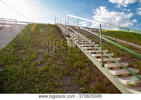 View Of A Concrete Staircase On The Slope Of A Road With Yellow Flowers On A Clear Sunny Day Of The 