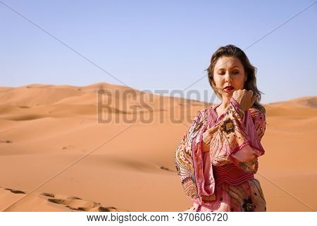 Girl In Moroccan Dress In Sahara Desert.